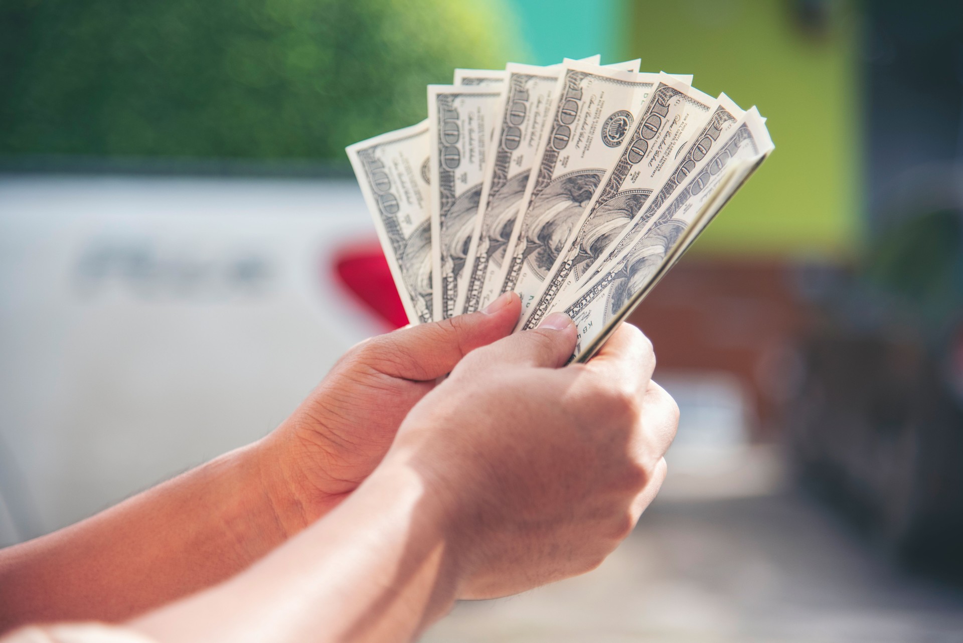 Hand holding money dollar bank note in wallet give financial payment. Man hands showing spread 100 dollar exchange cash payout. Saving Businessman counting money banknote bribe corruption concept.